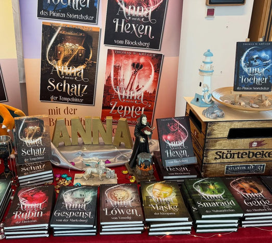 Book fair display of Thomas W. Krüger’s 'Anna' adventure series with fantasy-themed covers, treasure chest decorations, and a golden 'ANNA' sign.